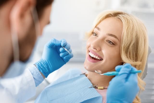 A dentist examining a patient’s teeth during a check-up